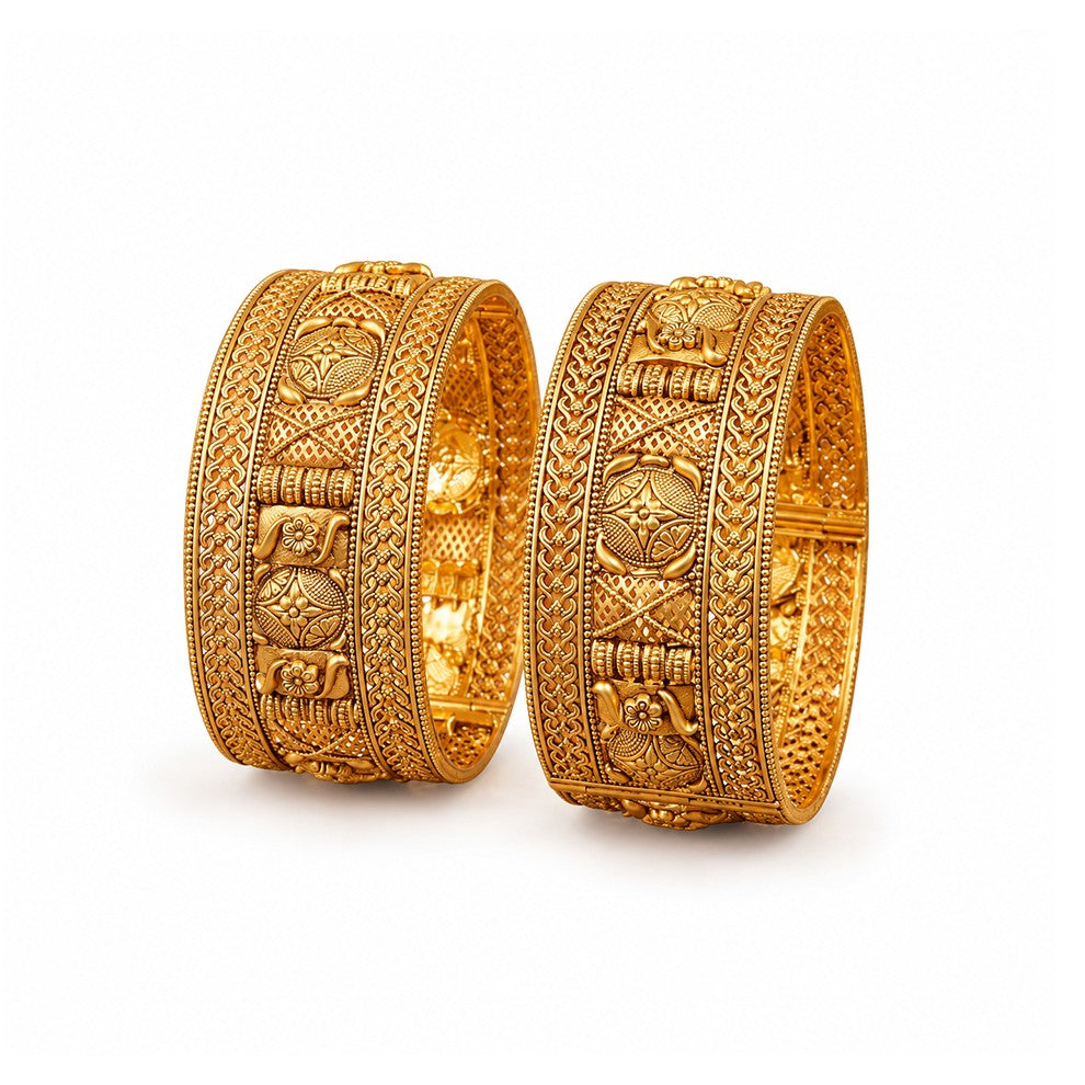Two ornate gold bracelets on a red surface with a green decorative plate in the background.
